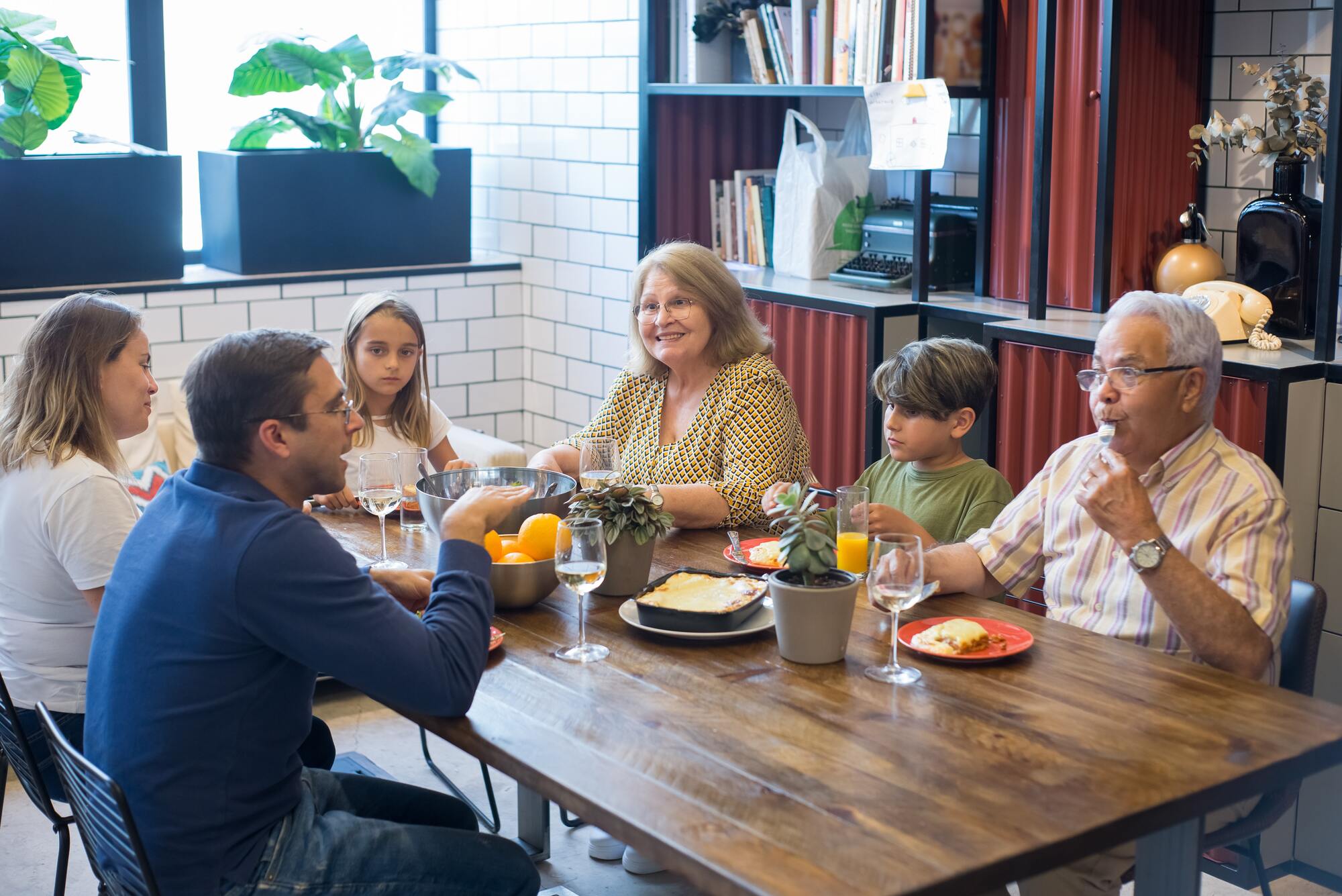 Family gathered at a table eating dinner together.