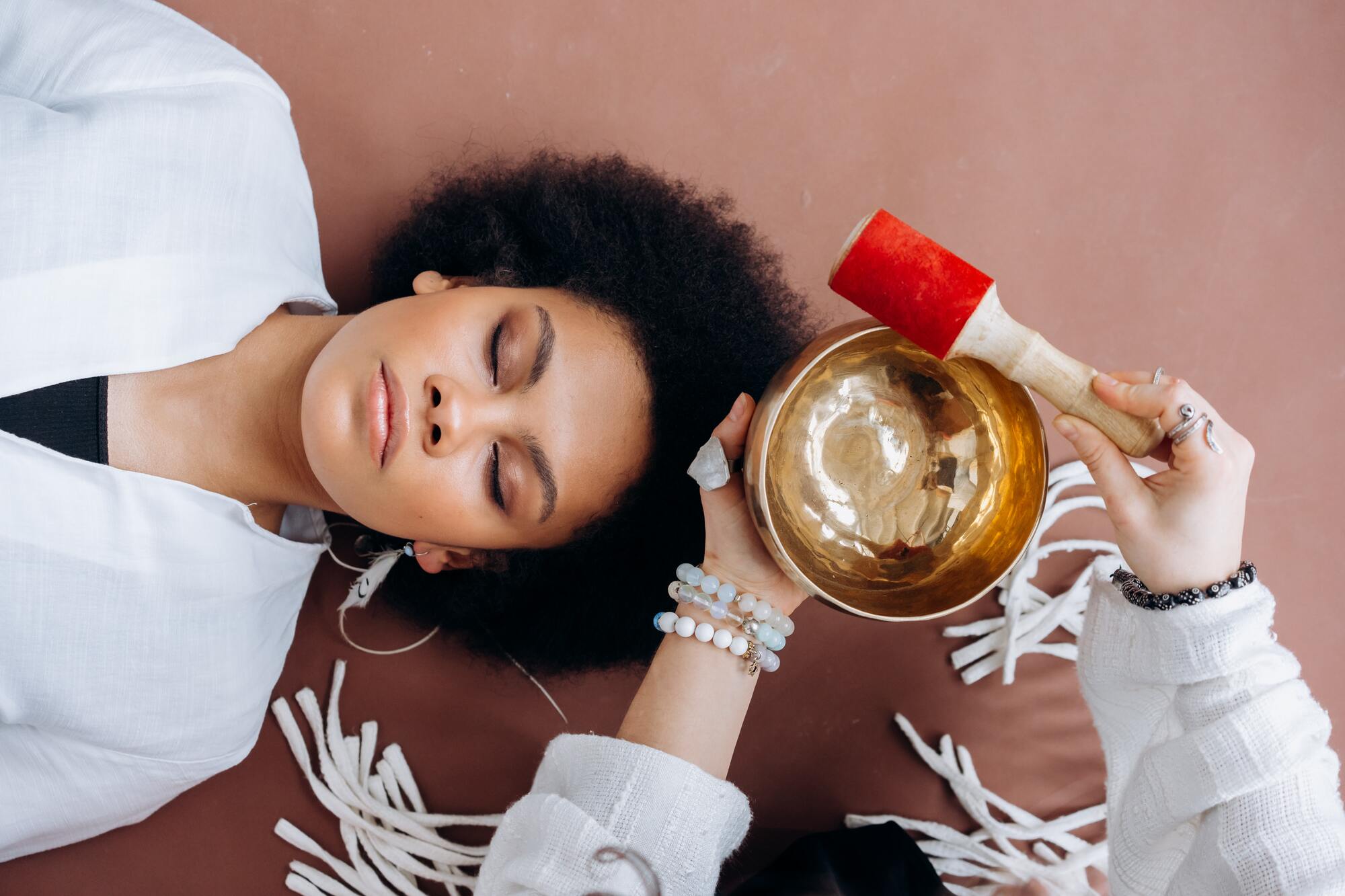 Woman relaxing in a reiki healing session with sound healing and crystals