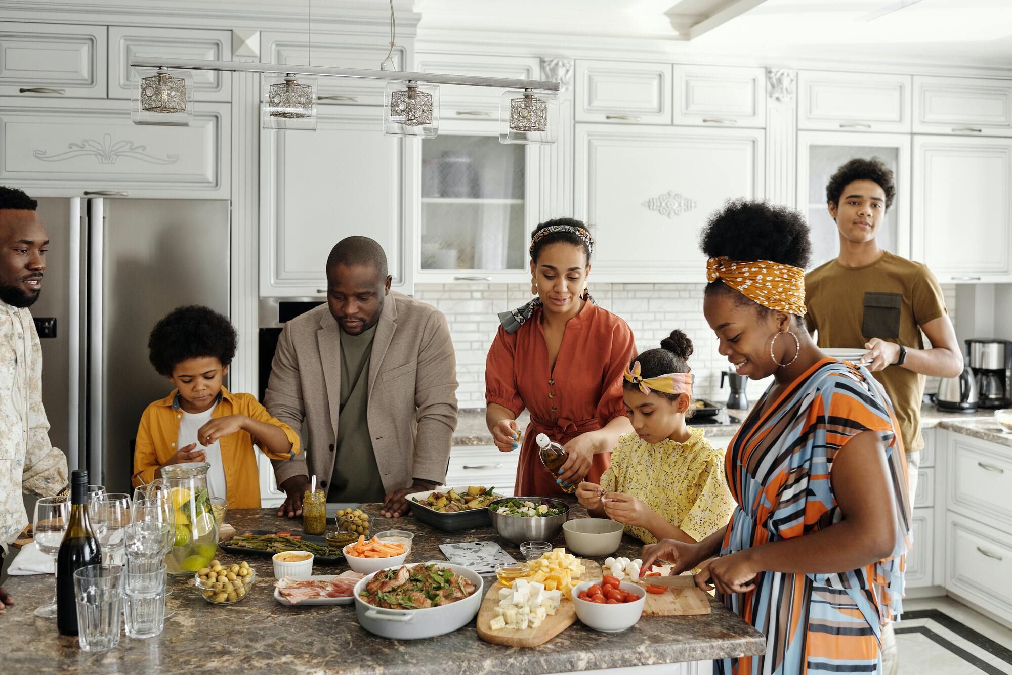 Family happily cooking together in home kitchen.