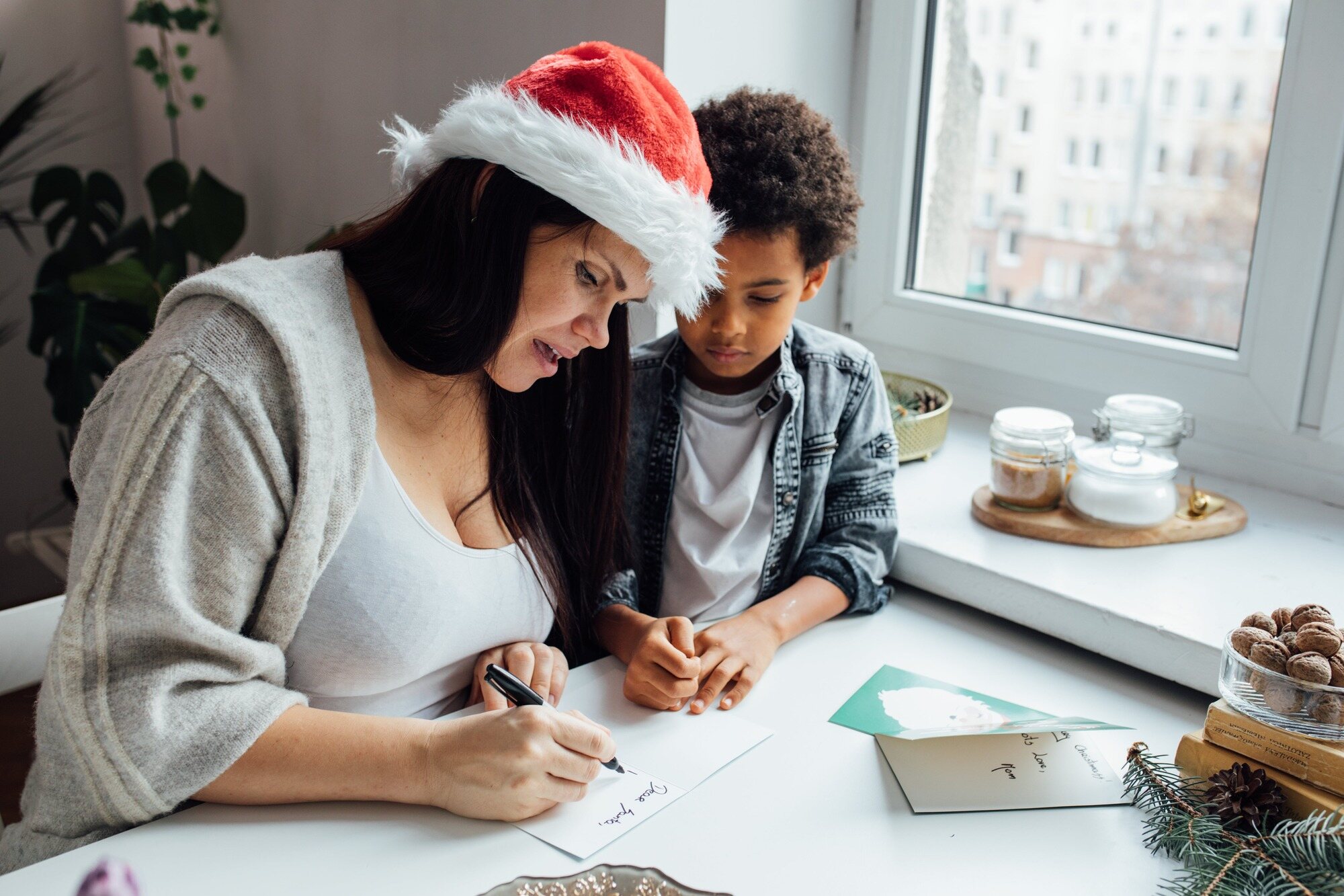 woman and child writing in holiday cards